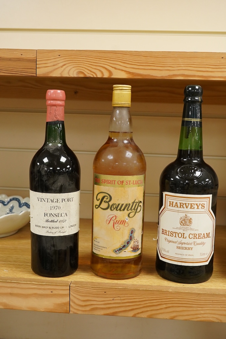 A bottle of Fonseca 1970 vintage port, a bottle of 1970 Chateau Grand-Puy-Lacoste, a litre bottle of Bounty rum and a litre bottle of Harvey’s Bristol Cream